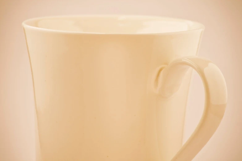 the coffee mug is cream colored, with a handle