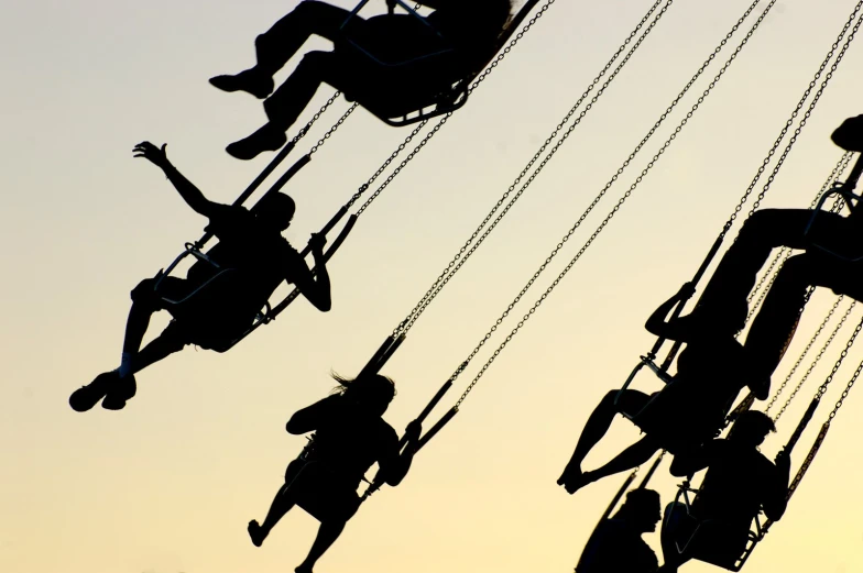 people ride on a carousel while the sun is setting