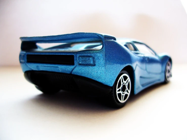 blue plastic model of a sports car on white surface