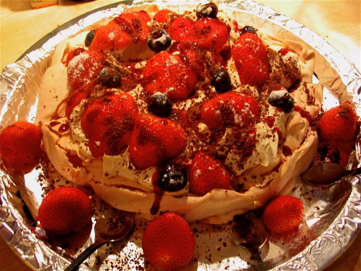 an image of a pastry covered in strawberries on foil