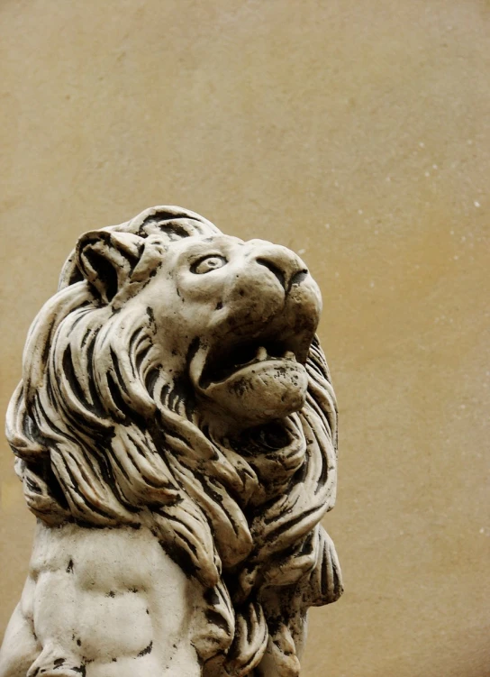 a statue of a lion is seen in front of a building