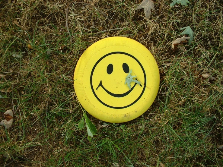 a yellow frisbee with a smiley face drawn on it