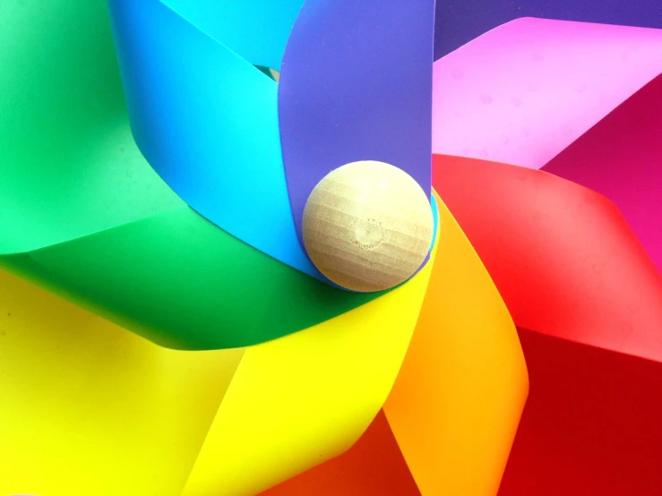 the wooden ball sits at the top of a colorful paper umbrella