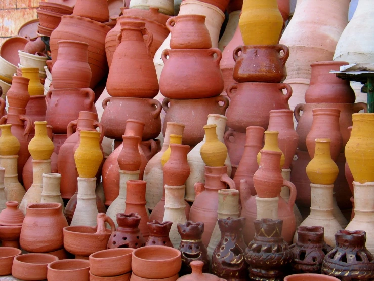 the big wall is full of different colored vases