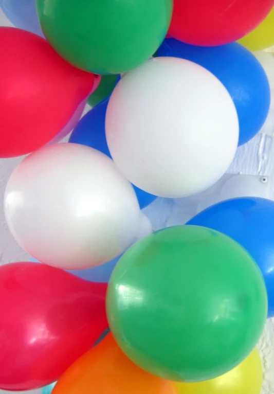 a bunch of balloons are piled high and in the air