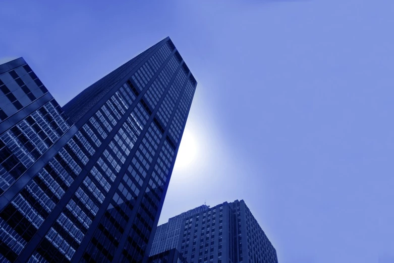 an airplane flying by between tall skyscrs