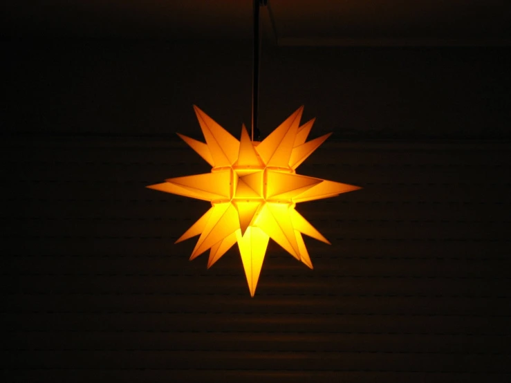 a moravian ornament at night is glowing yellow