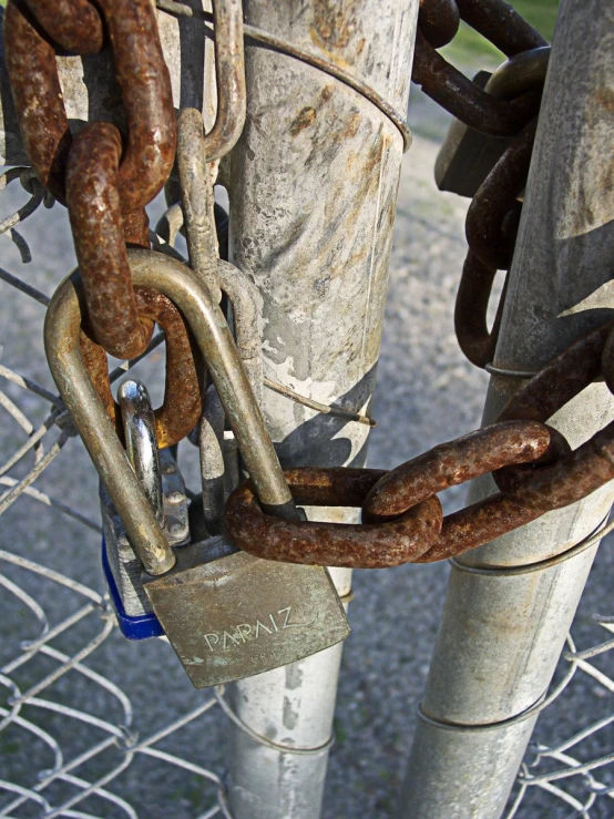 a bunch of rusty steel chains are hanging on a fence