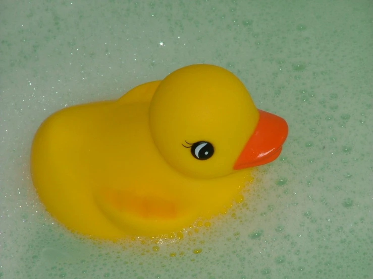 a rubber toy ducky is sitting in a bathtub