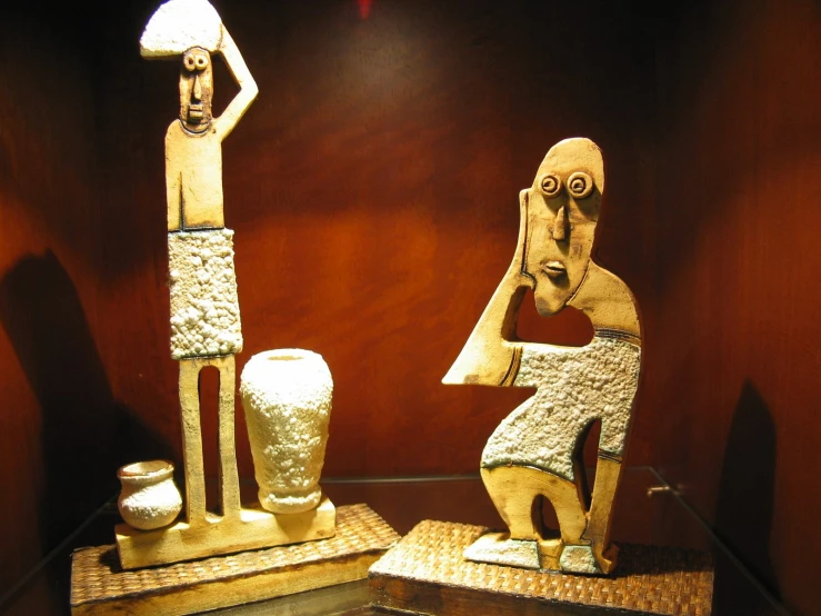 two ancient sculptures sitting in a display case
