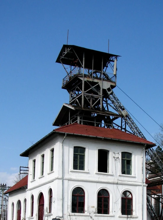 an old fashioned building with a tower with a large ladder coming out of it