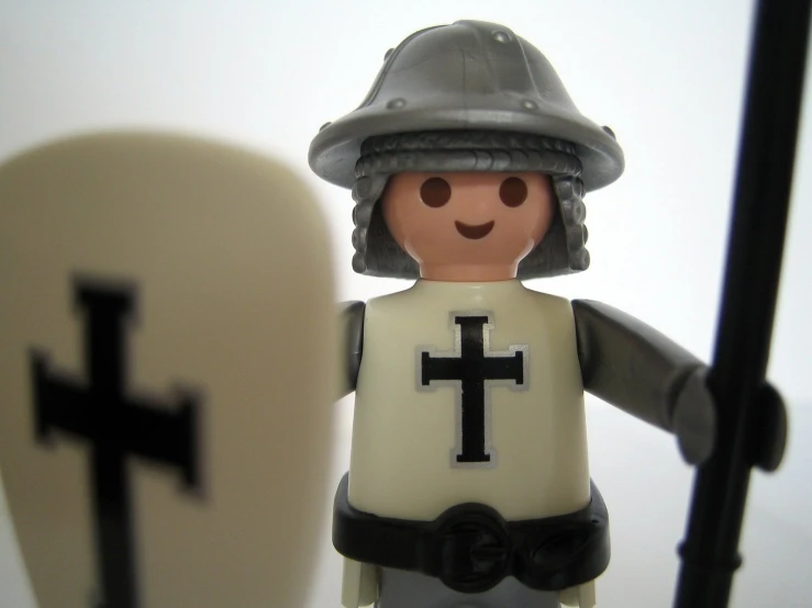 a small figurine is standing next to a cross