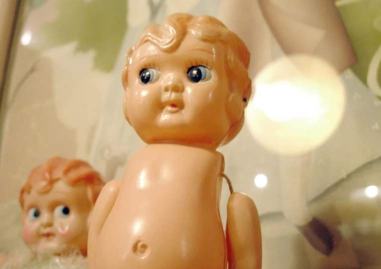 a ceramic baby doll with a red hair and blue eyes