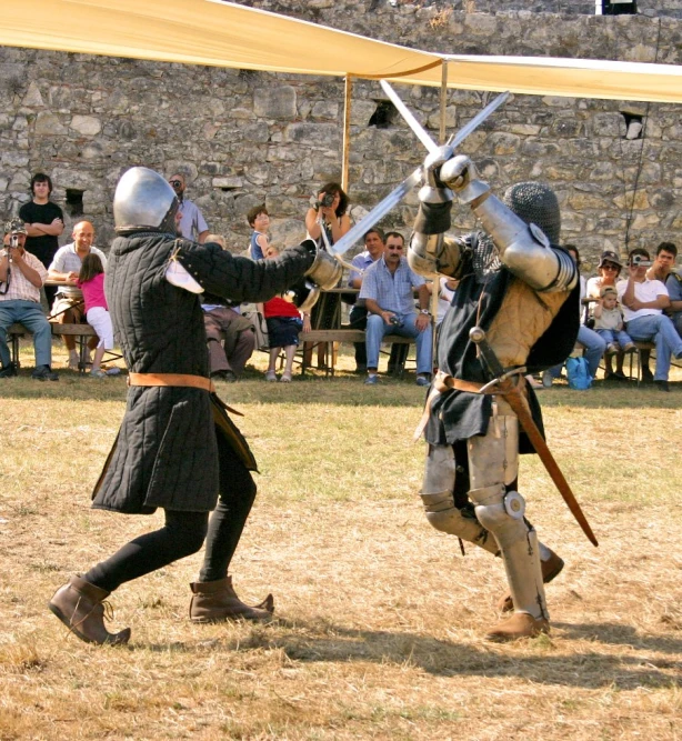 two men in armor are fighting with swords