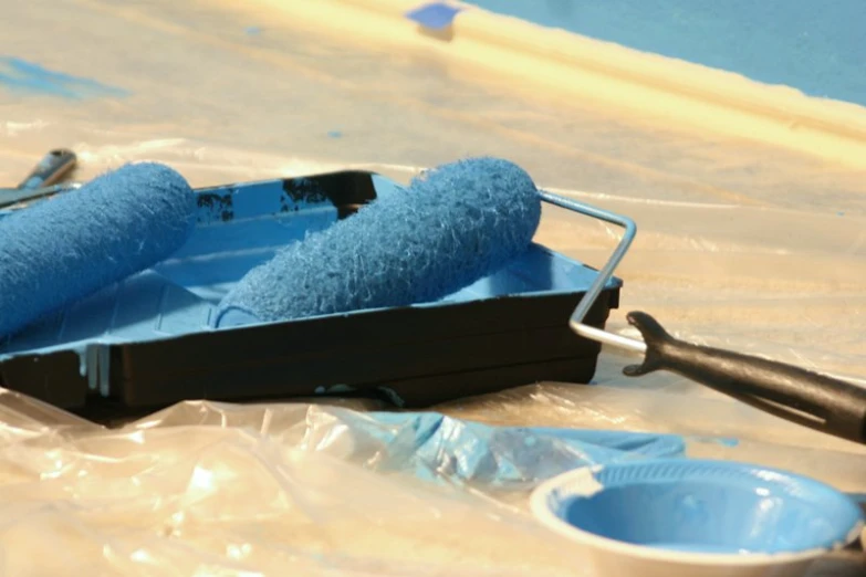 a set of tools sits on a plastic sheet next to some water