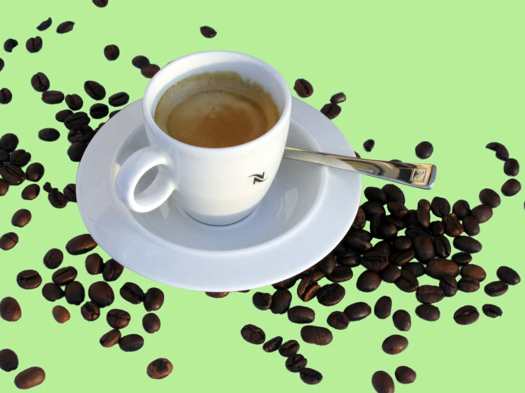 a white cup and saucer with coffee beans spilled on it