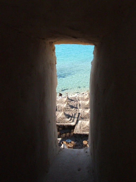 a view of a beach from the entrance to a cave