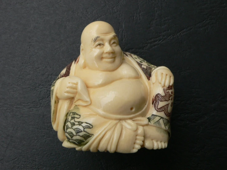 a buddha figurine sits against a black wall