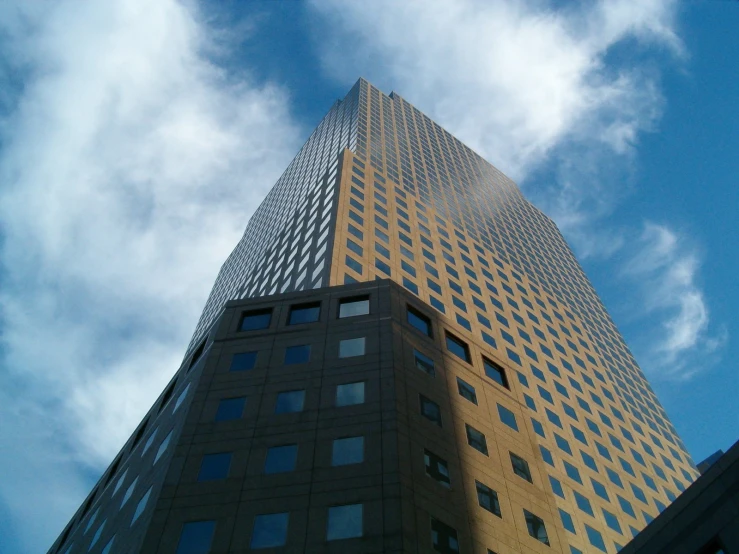 a tall skyscr building under a blue cloudy sky