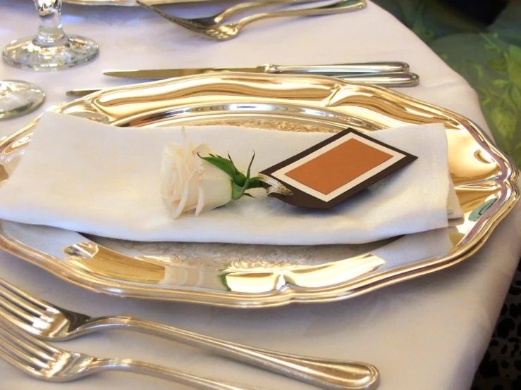 a rose and place setting on a silver tray