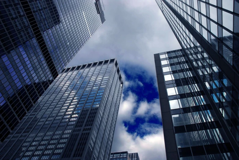 tall building towering above a cloudy sky filled with clouds