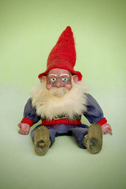 a small garden gnome with a white beard and green pants