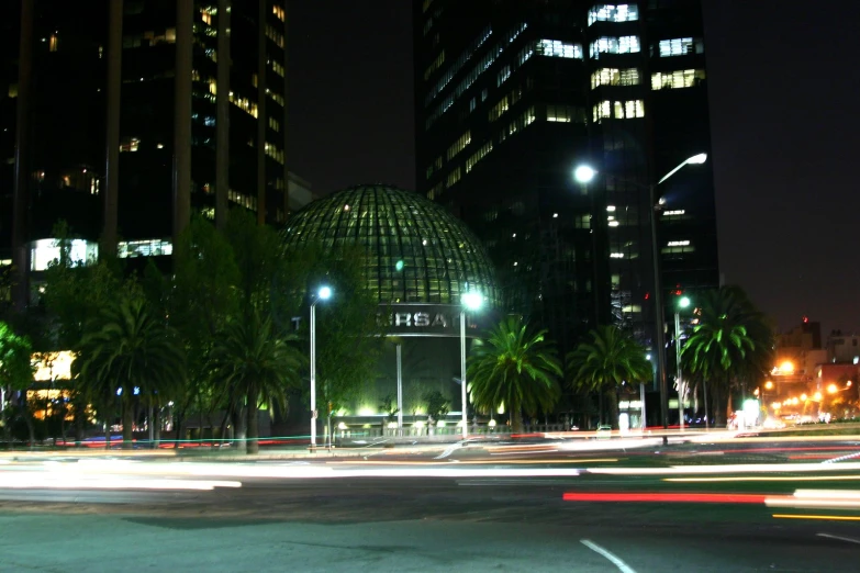 a view of city buildings at night with traffic lights