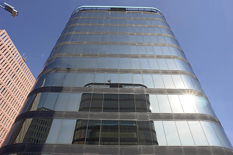 a skyscr with two large glass windows against a blue sky