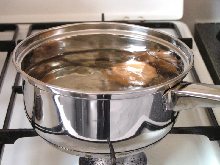 a shiny sauce pot sitting on the stove