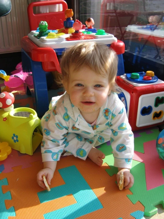 a baby is on the floor with lots of toys