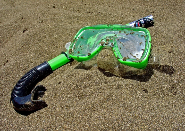 the scuba mask and goggles are in the sand