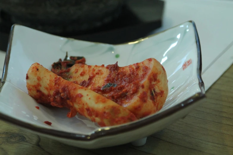 a white plate topped with pizza pieces sitting on top of a wooden table