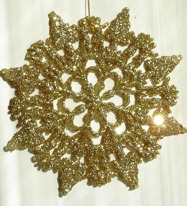 a christmas ornament shaped like a gold snowflake