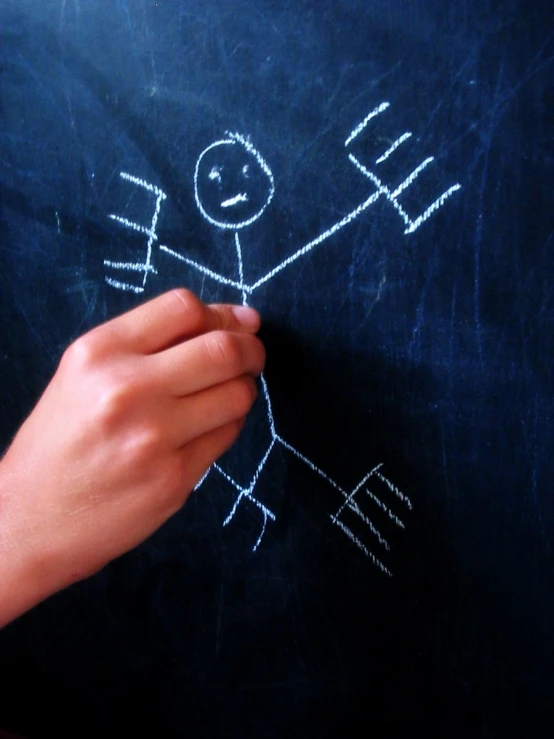 a person drawing on the blackboard with chalk