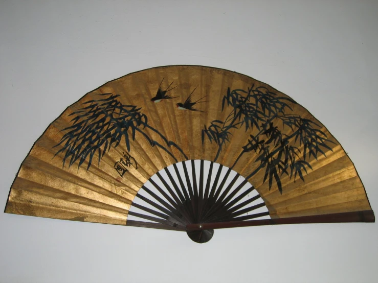 an old asian fan sitting up against a wall