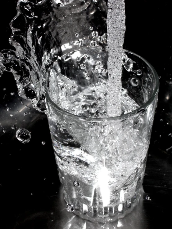 a glass filled with water with a metal handle