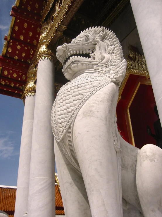 a statue of a lion next to several pillars