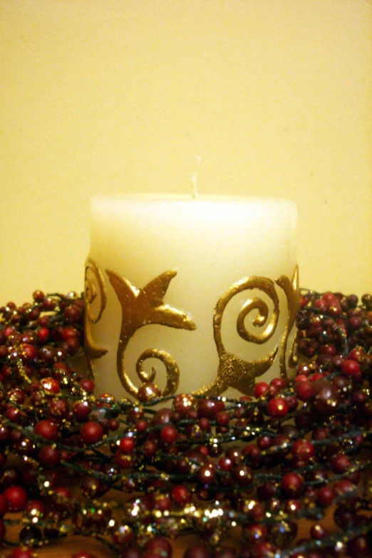 a candle sits on a table in front of beads