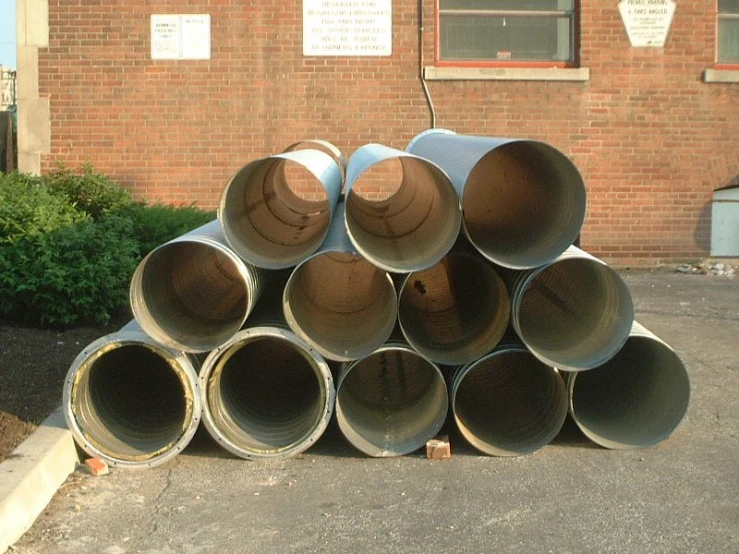 large pipe stack up with the side of a building behind