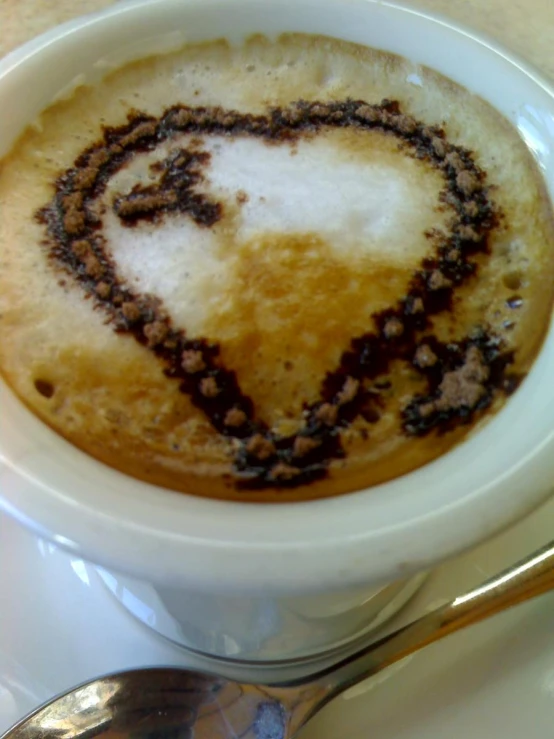 a heart shaped pastry in a cup with some coffee powder on top