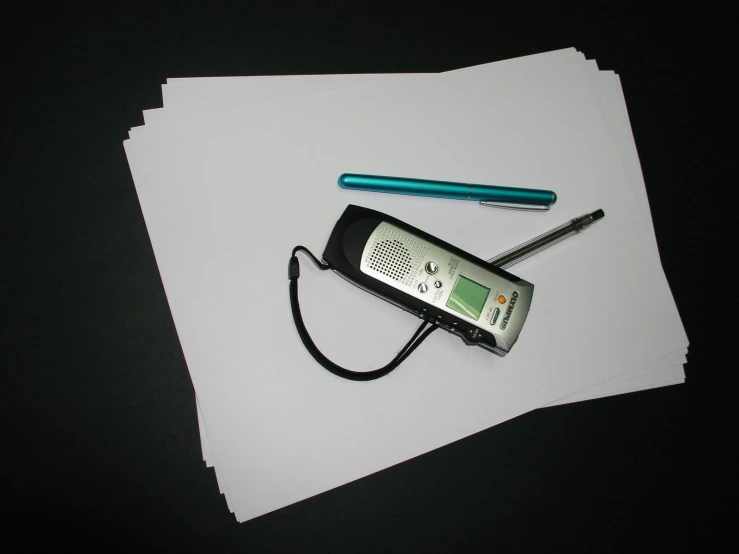 a cellphone laying next to another cell phone on top of paper