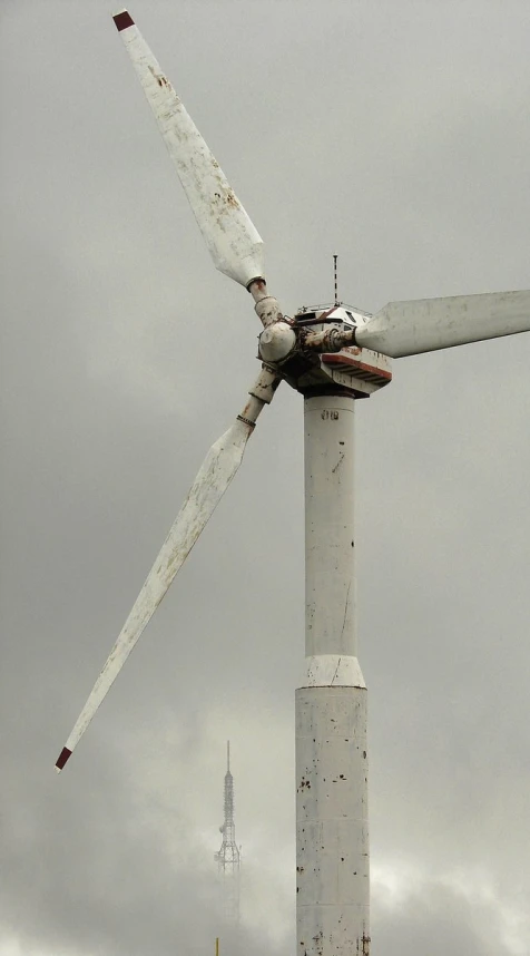 a windmill with several blades is on top of a tall pole
