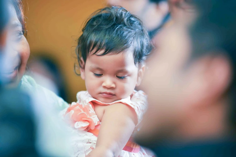 a baby is looking down at her moms arm