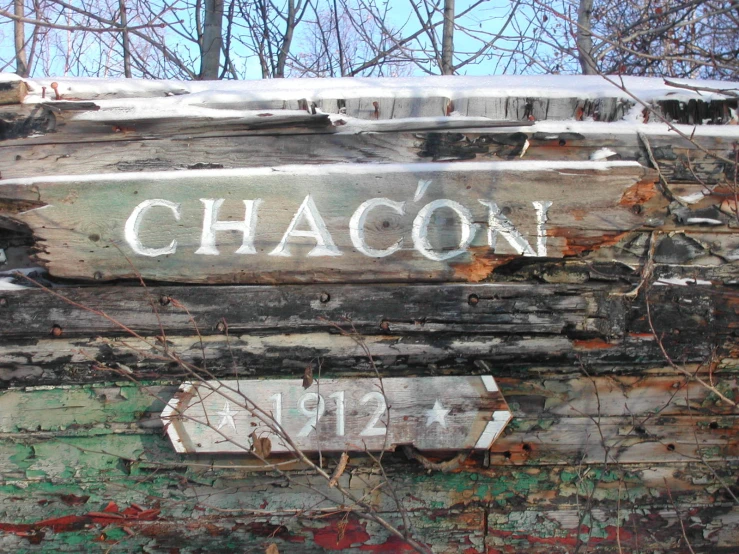 a very old rusted piece of metal with some faded signs on it