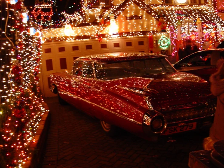 a car parked in front of a house covered with christmas lights