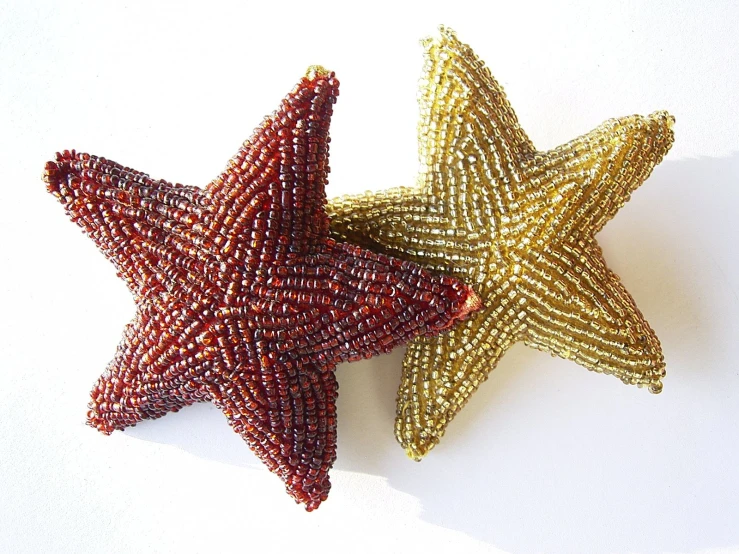 two star sculptures are shown on a white background