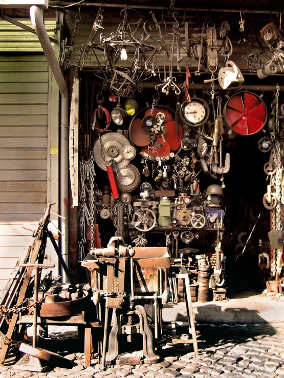 an open shopfront shows various metal items, such as clocks and stools