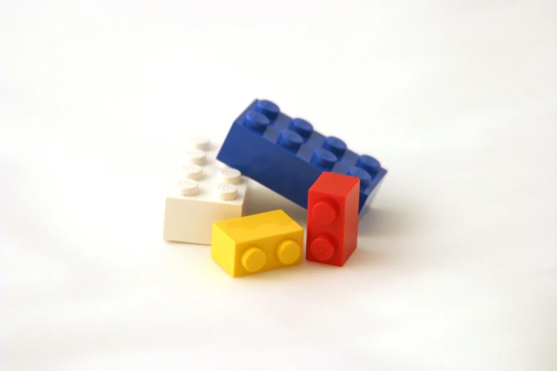 three pieces of plastic lego sit beside each other