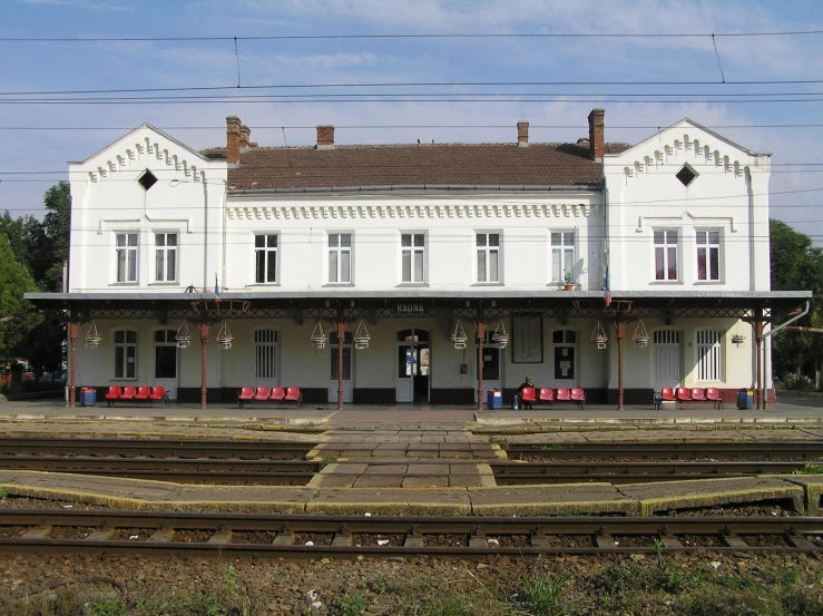 a long empty train station with three train tracks in front of it