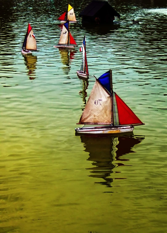 several small sailboats sitting in the water